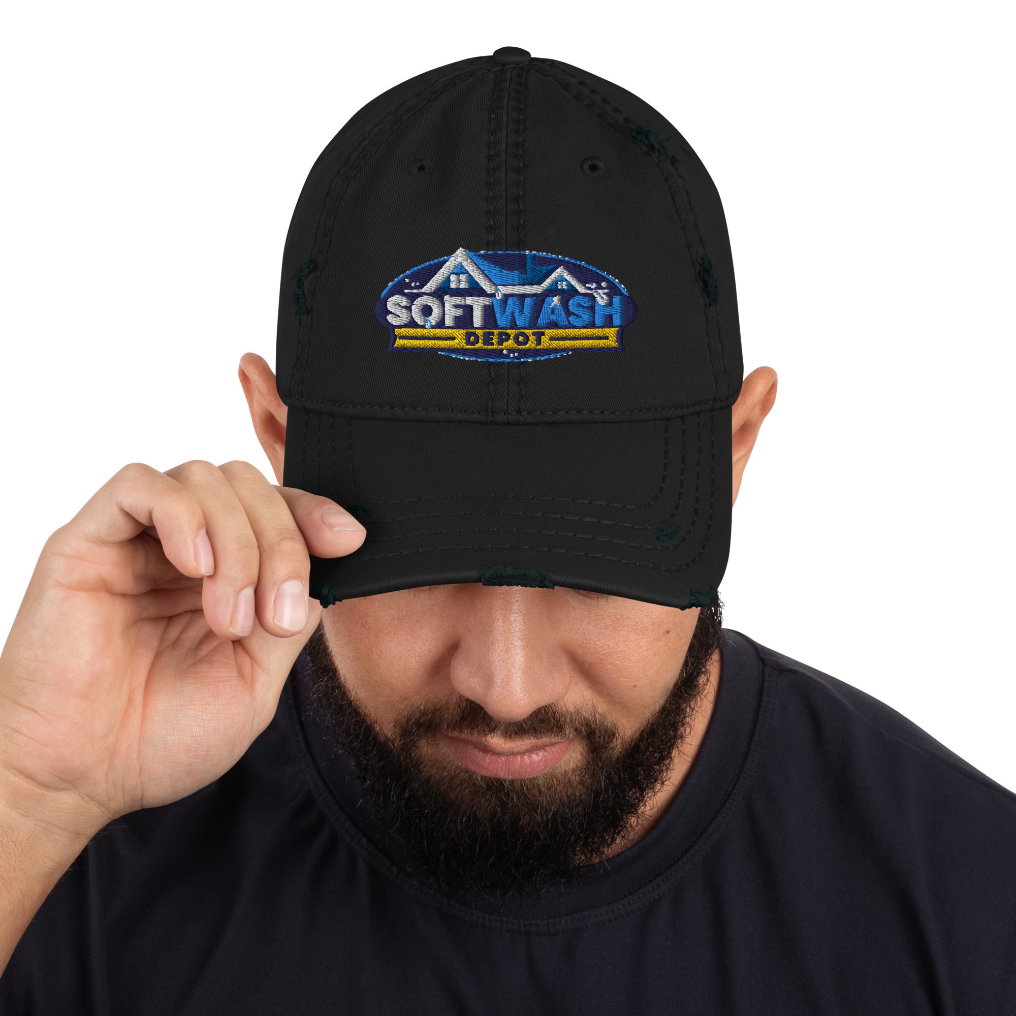 Man wearing a black distressed dad hat with the Soft Wash Depot embroidered logo on the front, adjusting the brim while looking down. - Soft Wash Depot