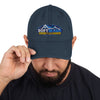 Man wearing a black distressed dad hat with the Soft Wash Depot embroidered logo on the front, adjusting the brim while looking down. - Soft Wash Depot